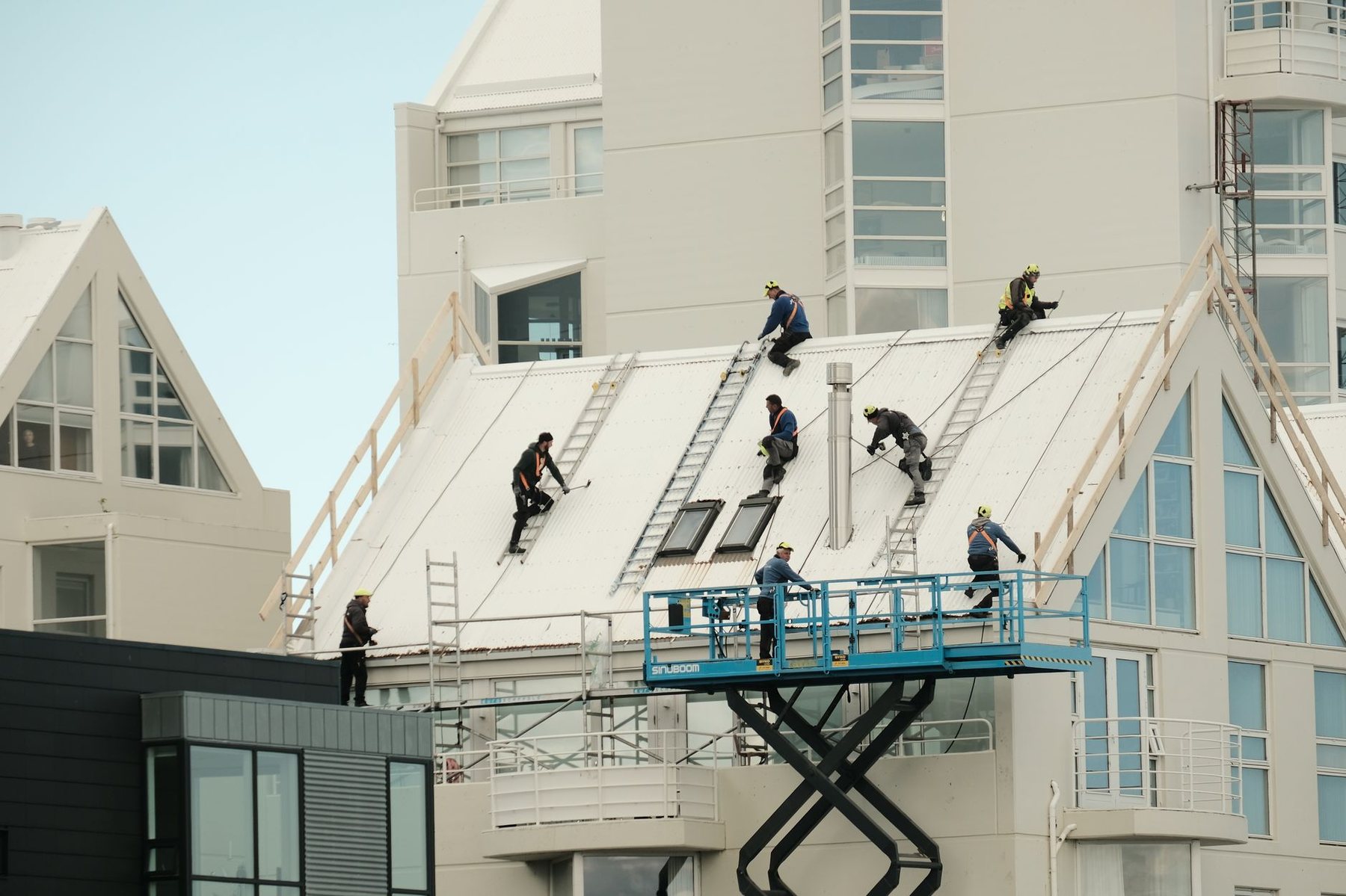 Trabajos de pintura en la fachada de un edificio desde una plataforma